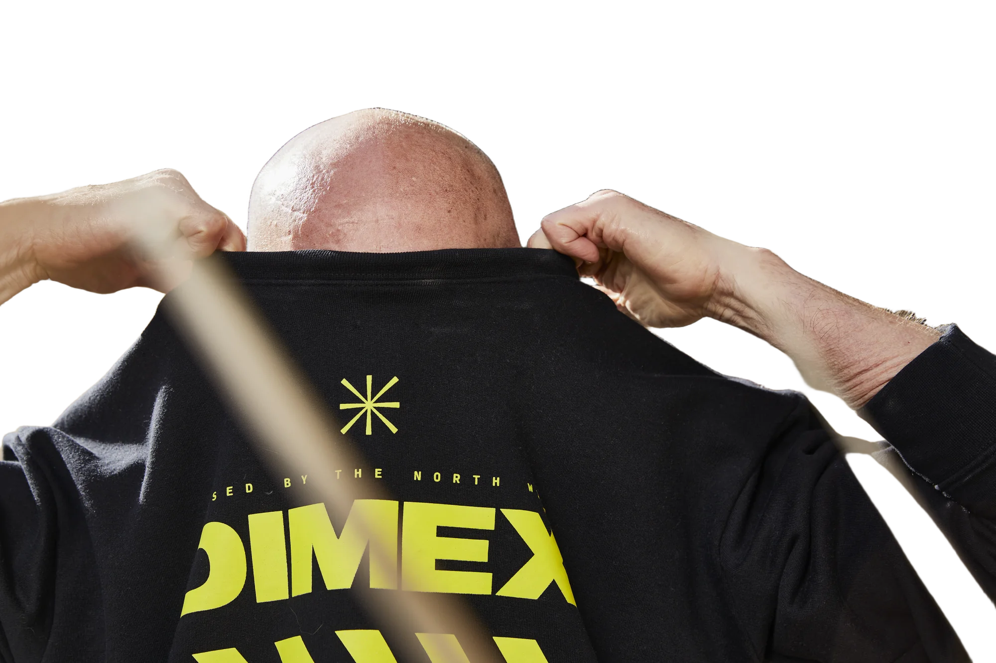 Man pulling off a black Dimex sweatshirt, steam rising off his head and arms